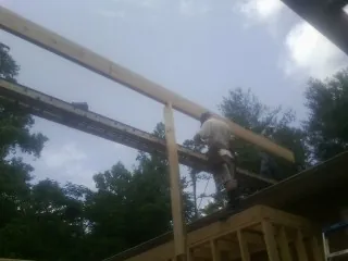 Carpenter setting a ridge beam over a new addition frame — Ice Dam Removal by Roofing Brothers in Bridgeview